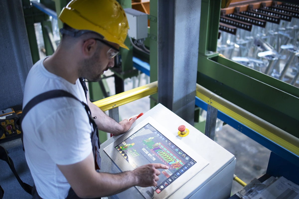 A man in yellow hard hat working on a game.