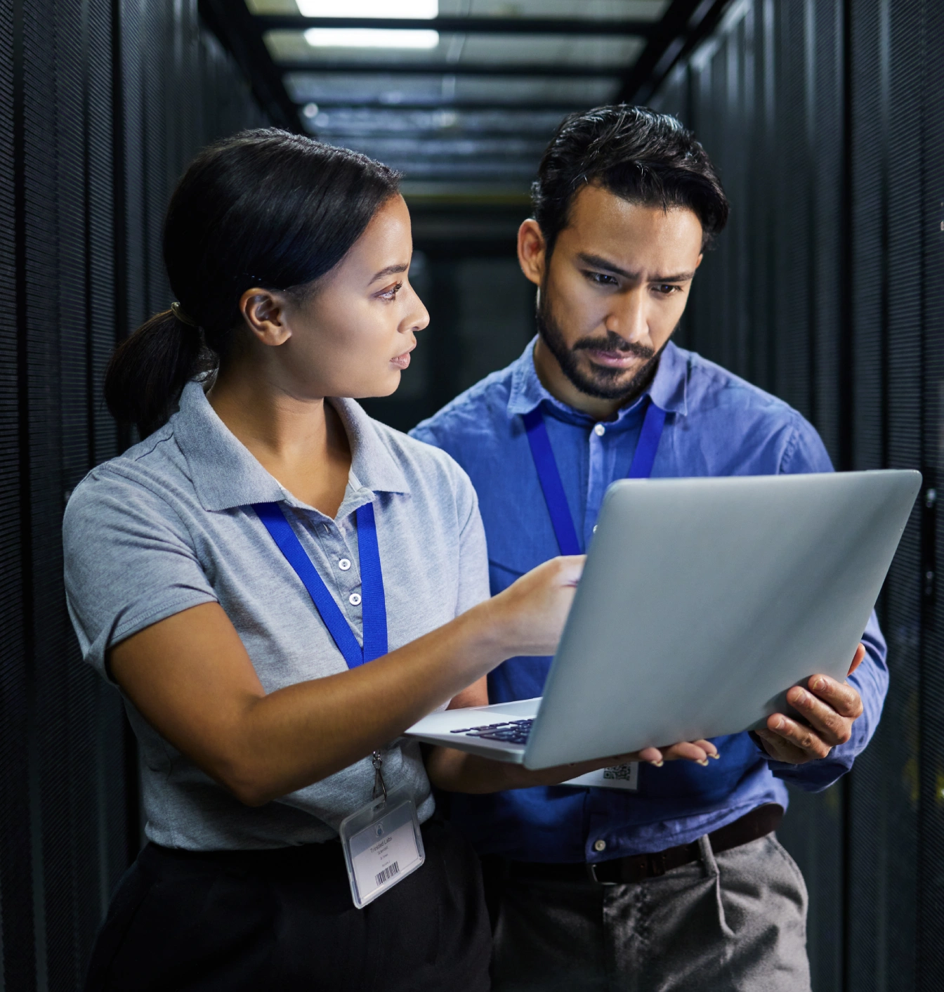 Two IT professionals reviewing data on laptop.