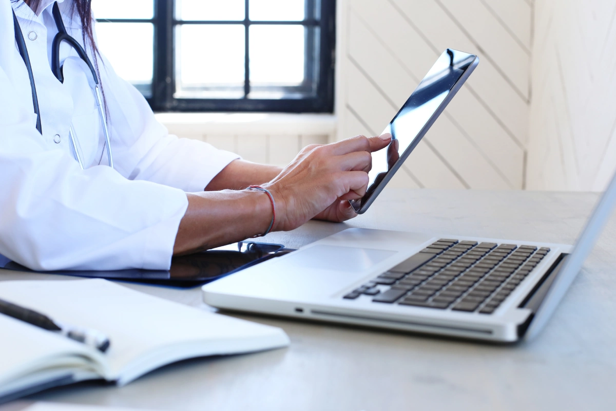 A person using a tablet on top of a desk.