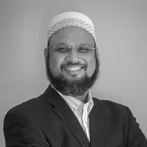 A man in a suit and hat smiling for the camera.