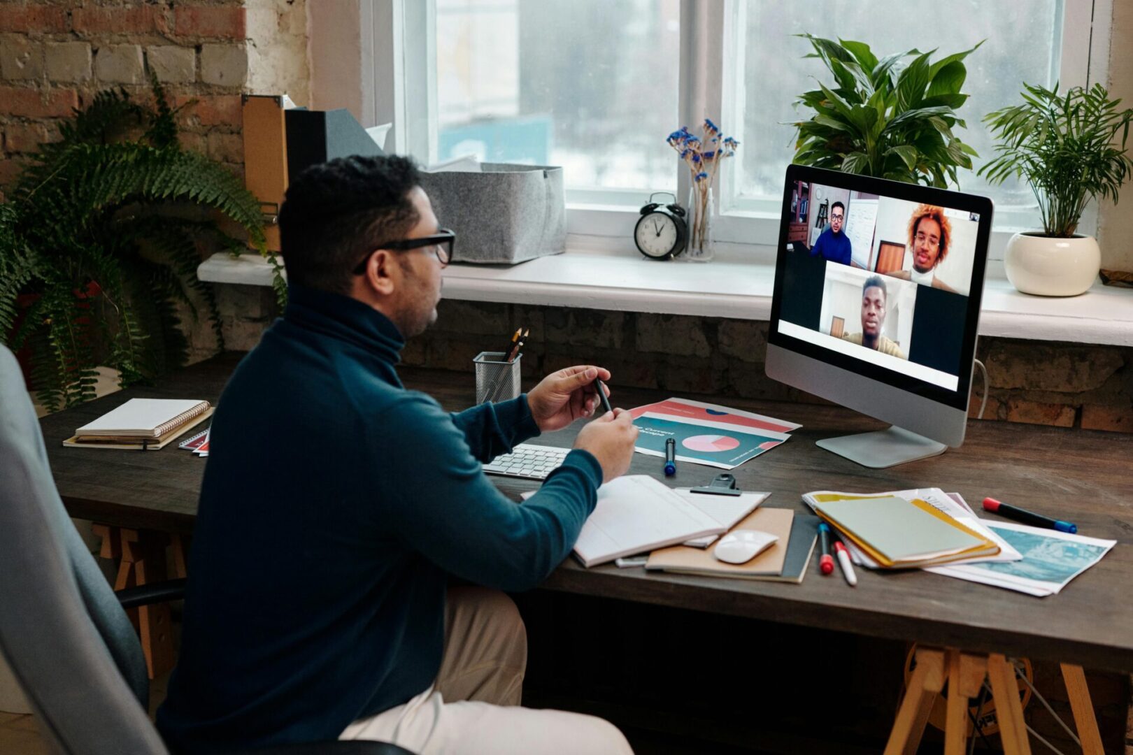 A man sitting at his desk in front of a computer.