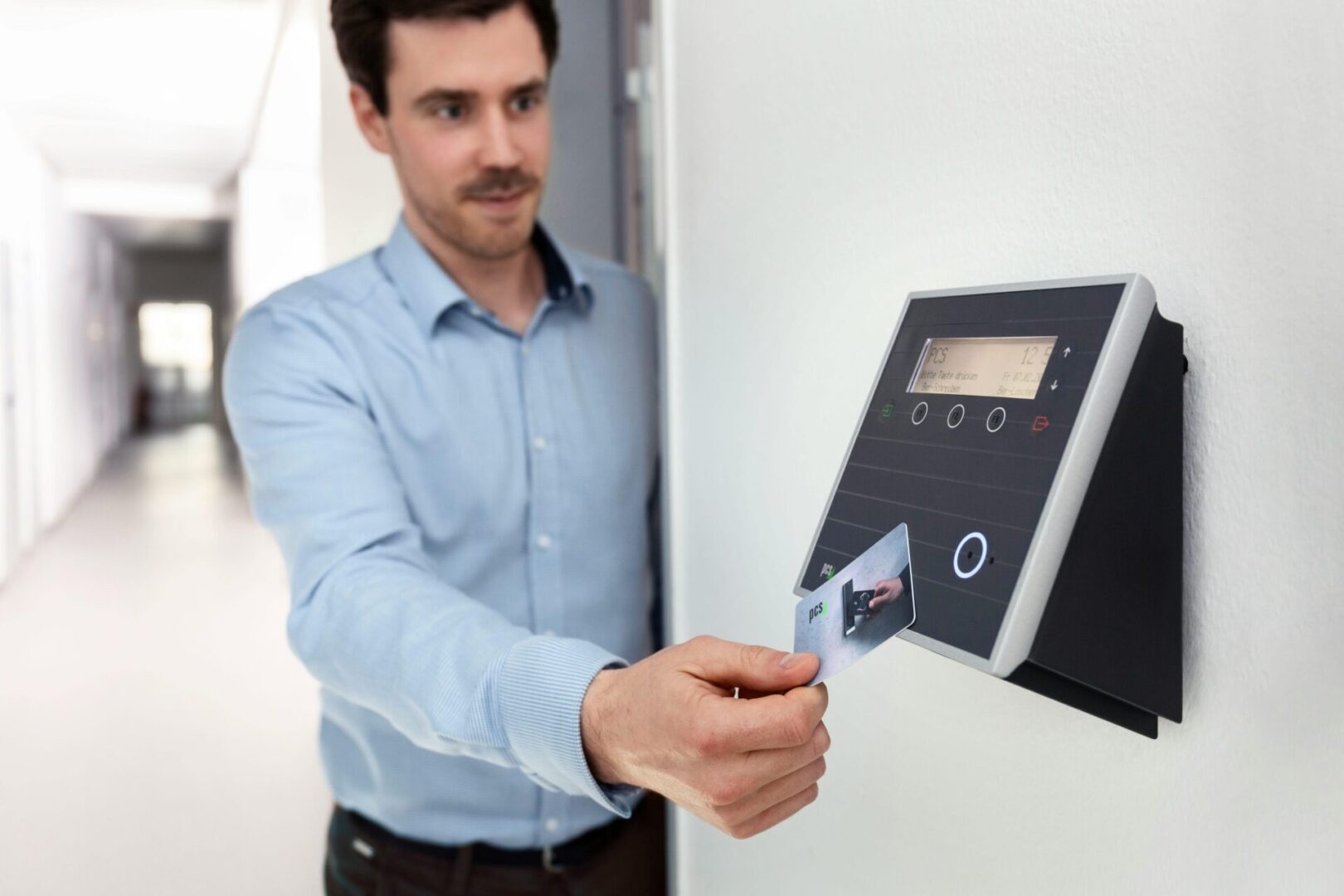 A man is putting his id card into the machine.