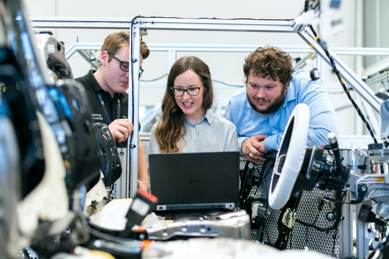 Three people looking at a laptop in a lab.