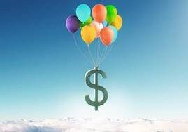 A dollar sign floating in the sky with balloons.