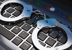 A pair of handcuffs sitting on top of a keyboard.